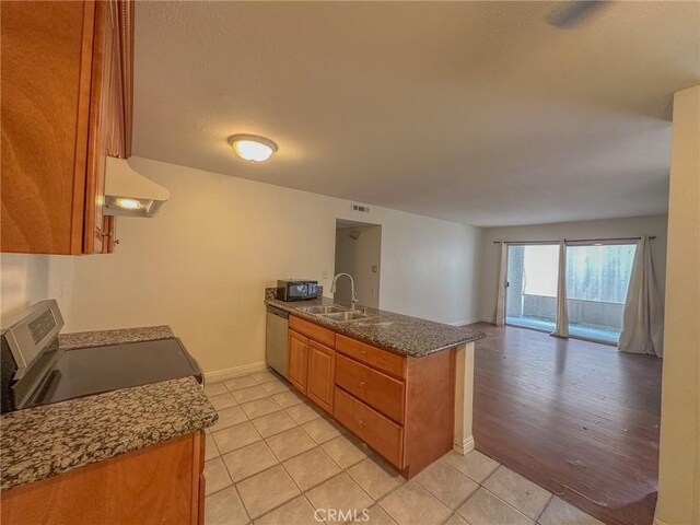 kitchen featuring sink, light tile patterned floors, stainless steel appliances, ventilation hood, and kitchen peninsula