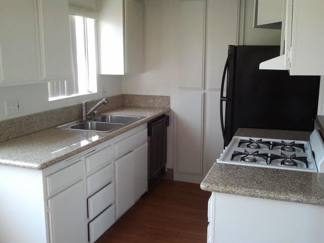 kitchen with dark wood-type flooring, black appliances, sink, and white cabinets