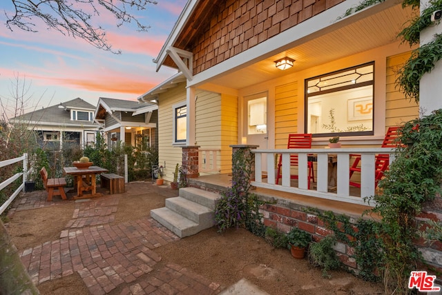 exterior entry at dusk featuring a patio area