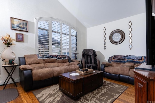 living room featuring lofted ceiling, light hardwood / wood-style flooring, and a baseboard radiator