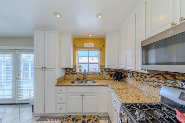 kitchen featuring white cabinetry, sink, light stone counters, and stainless steel appliances