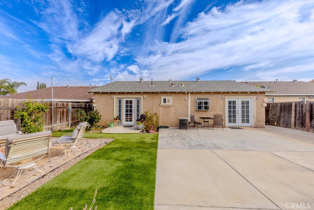 back of house featuring french doors, central AC, a patio, and a lawn