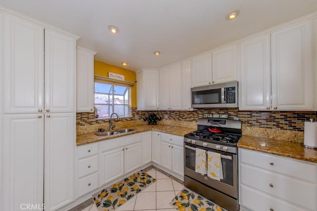 kitchen with white cabinetry, sink, light tile patterned floors, and appliances with stainless steel finishes