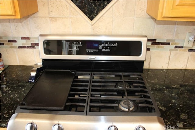 room details with tasteful backsplash, dark stone countertops, light brown cabinetry, and stainless steel gas stove