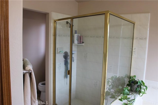 bathroom featuring an enclosed shower and toilet