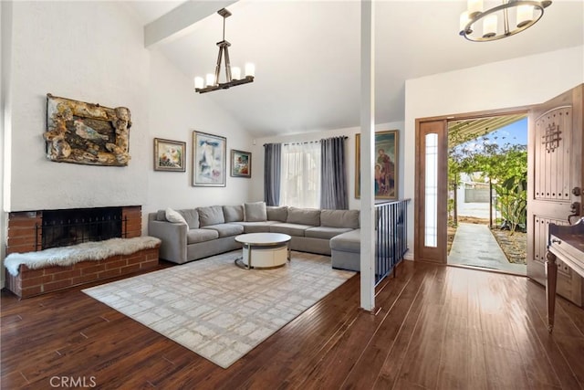 living room featuring wood-type flooring, a chandelier, high vaulted ceiling, a brick fireplace, and beamed ceiling