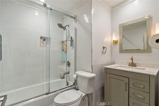 full bathroom featuring toilet, crown molding, shower / bath combination with glass door, tile walls, and vanity