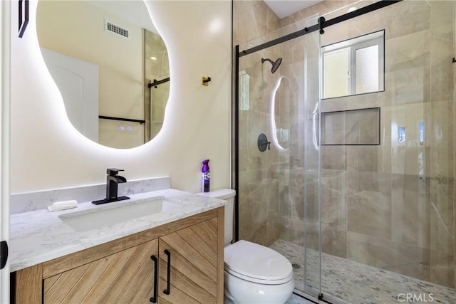 bathroom with vanity, an enclosed shower, and toilet