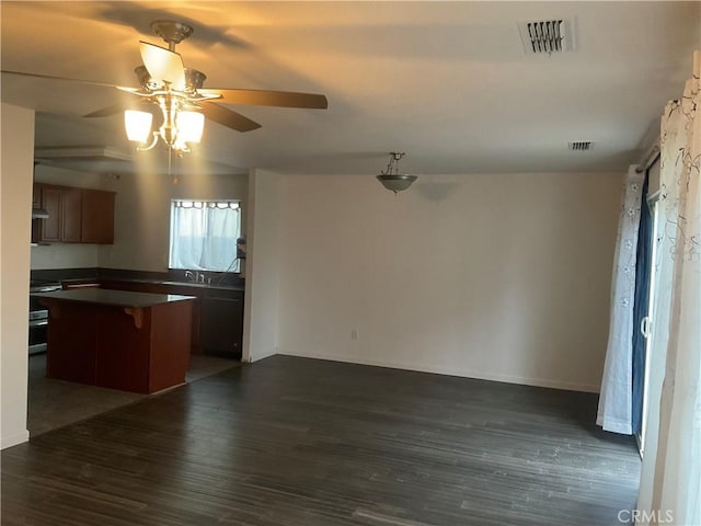 kitchen featuring extractor fan, a center island, a kitchen breakfast bar, dark hardwood / wood-style flooring, and range