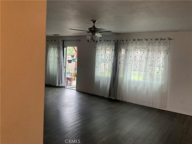 spare room featuring ceiling fan and dark wood-type flooring