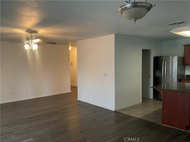 unfurnished room with a textured ceiling, ceiling fan, and dark hardwood / wood-style floors