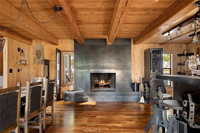 dining room featuring hardwood / wood-style flooring, a fireplace, wooden walls, and wood ceiling