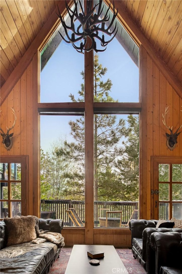 interior space with wooden walls, high vaulted ceiling, and wooden ceiling