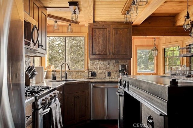 kitchen with sink, tasteful backsplash, pendant lighting, stainless steel appliances, and beam ceiling