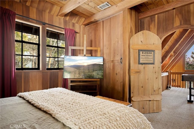 bedroom with beamed ceiling, carpet flooring, wood ceiling, and wooden walls