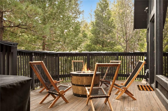 wooden terrace featuring an outdoor fire pit