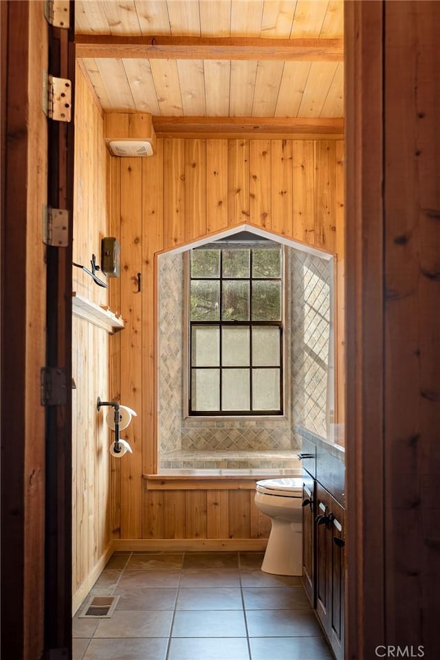 bathroom with wood ceiling, toilet, tile patterned flooring, and wood walls