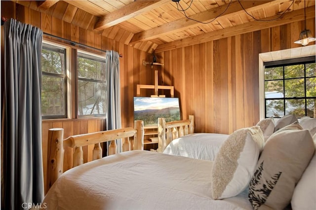 bedroom with multiple windows, wood ceiling, and wooden walls