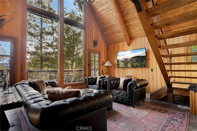 living room with plenty of natural light, high vaulted ceiling, and wood walls