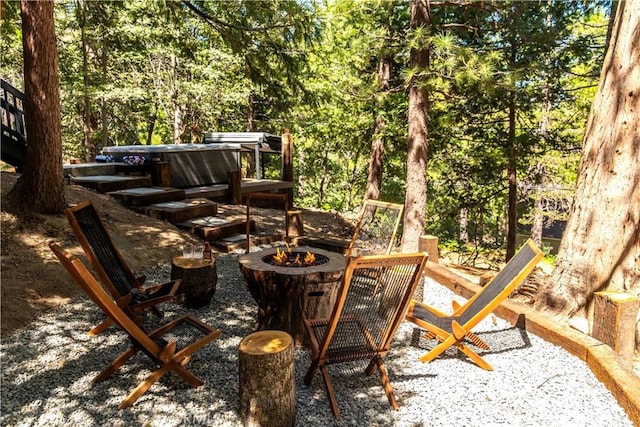 view of patio / terrace featuring a hot tub and a fire pit