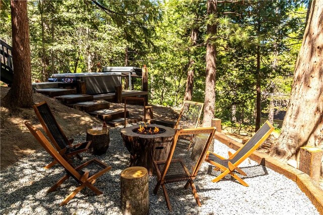 view of patio / terrace featuring a fire pit and a hot tub