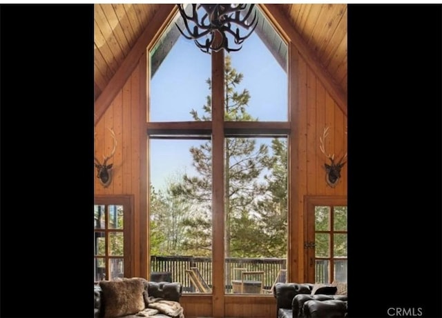 interior space featuring high vaulted ceiling, wooden walls, and wooden ceiling