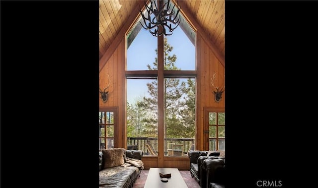 interior space with a notable chandelier, wooden walls, and wooden ceiling