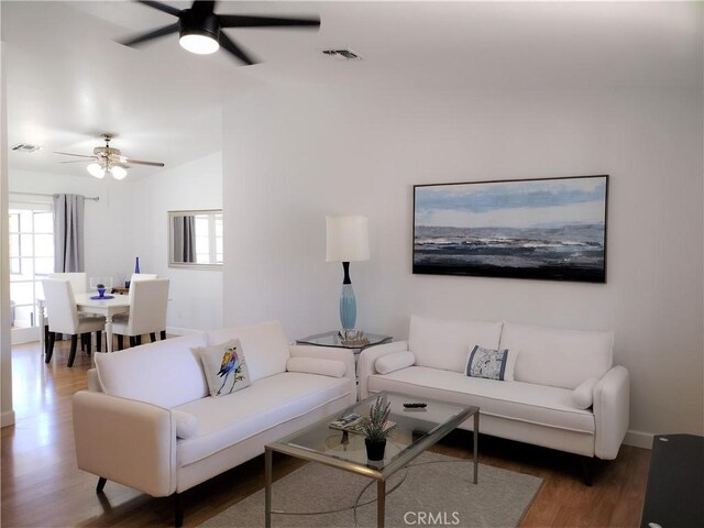 living room featuring hardwood / wood-style floors, vaulted ceiling, and ceiling fan