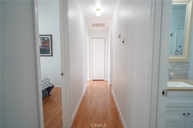 corridor with sink and light hardwood / wood-style floors