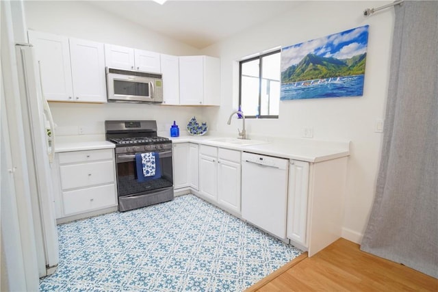 kitchen featuring white cabinetry, appliances with stainless steel finishes, sink, and lofted ceiling