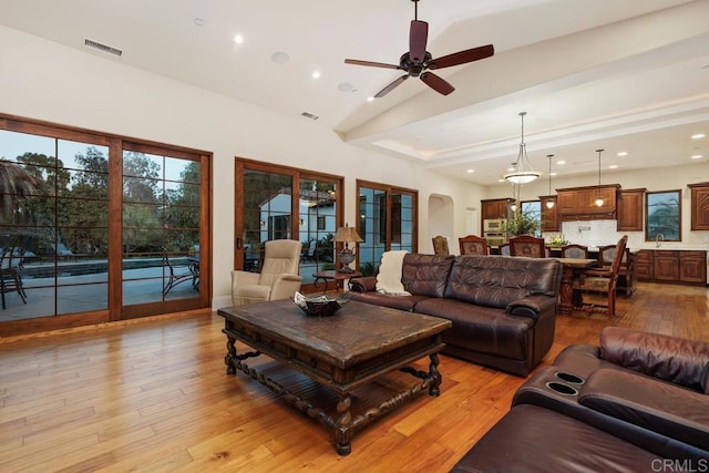 living room with ceiling fan, high vaulted ceiling, sink, and light wood-type flooring