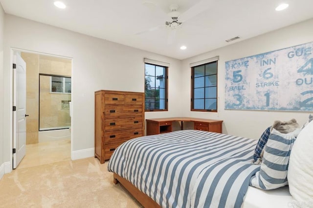 bedroom featuring light carpet, ensuite bath, and ceiling fan