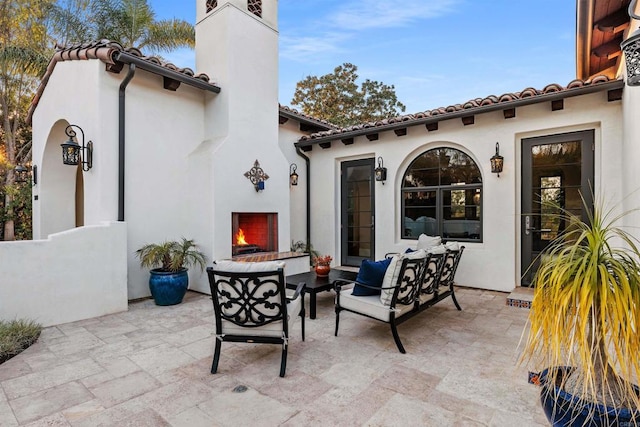 view of patio with an outdoor living space with a fireplace