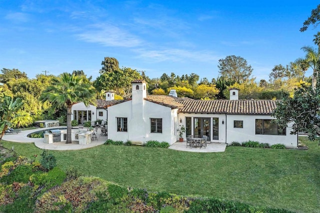 back of property featuring a patio and a lawn