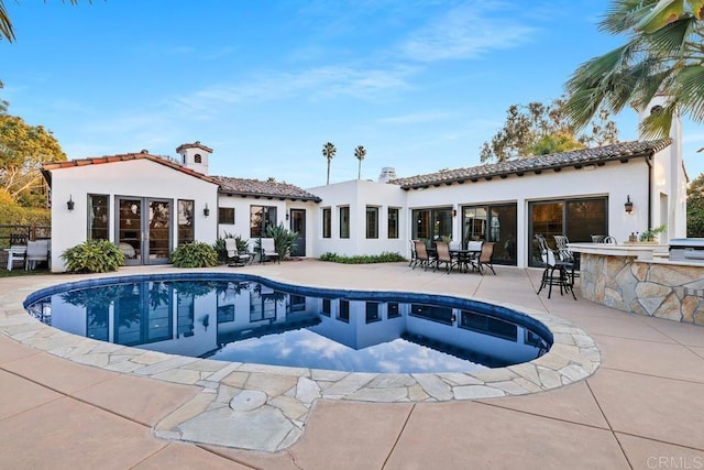 rear view of property featuring a patio and exterior bar