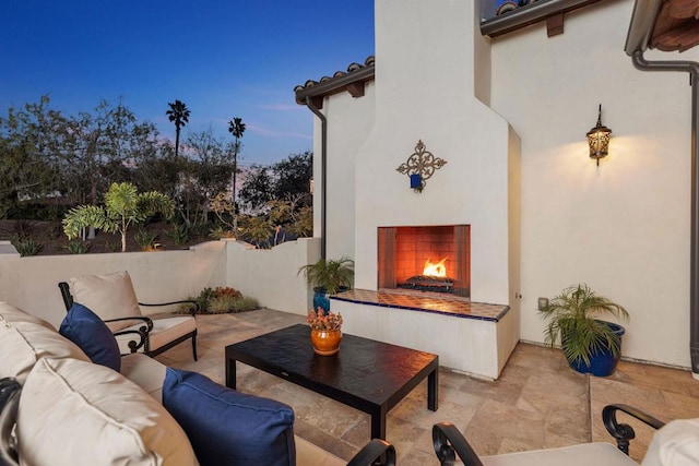 patio terrace at dusk featuring an outdoor living space with a fireplace