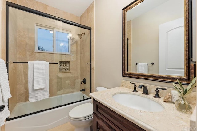 full bathroom with bath / shower combo with glass door, vanity, and toilet