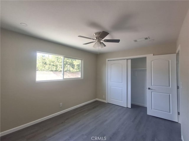 unfurnished bedroom with a closet, dark hardwood / wood-style floors, and ceiling fan