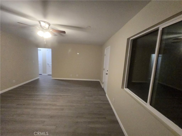 empty room with dark hardwood / wood-style floors and ceiling fan