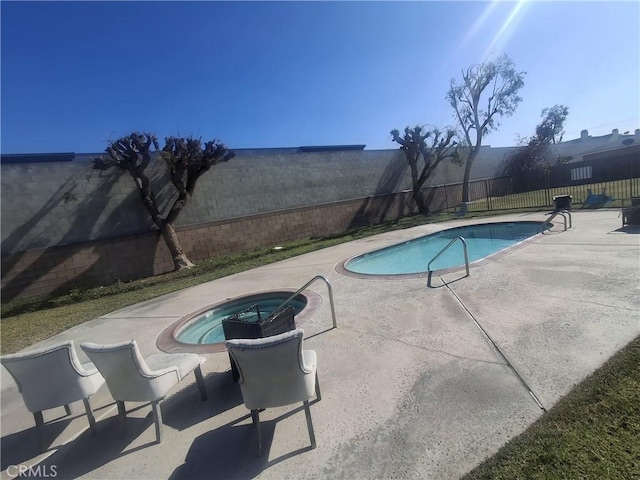 view of pool with an in ground hot tub and a patio