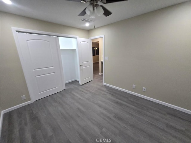 unfurnished bedroom with dark wood-type flooring, ceiling fan, and a closet