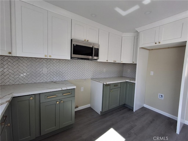 kitchen with white cabinetry, tasteful backsplash, light stone countertops, and dark hardwood / wood-style floors