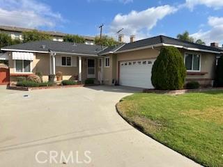 single story home featuring a garage and a front lawn