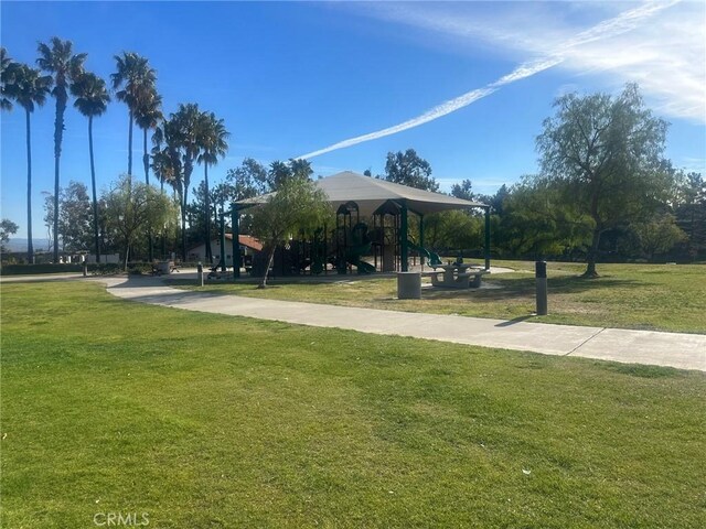 view of property's community with a playground and a lawn