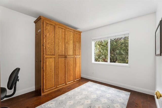 unfurnished bedroom with dark wood-type flooring