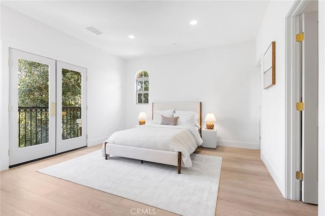 bedroom with french doors, access to outside, and light hardwood / wood-style flooring