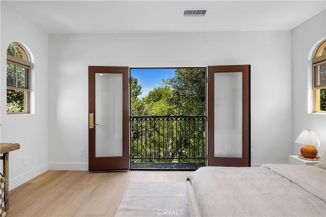 bedroom with light wood-type flooring and french doors