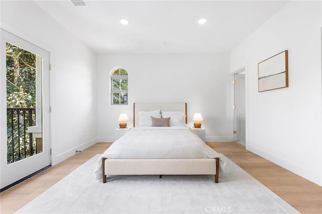 bedroom featuring access to exterior and light hardwood / wood-style flooring