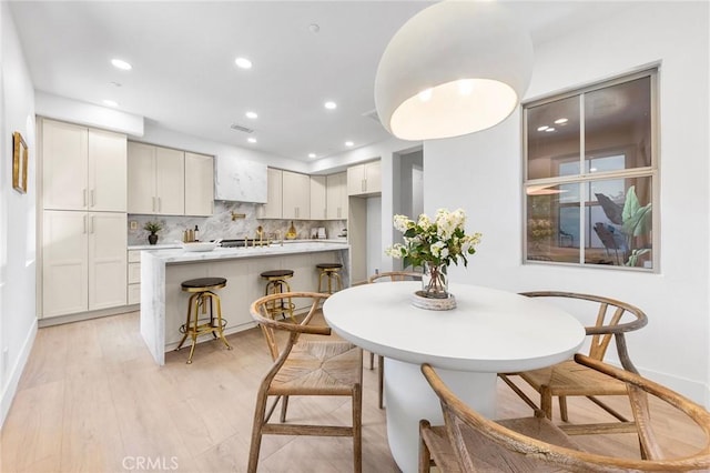 dining space featuring sink and light hardwood / wood-style floors