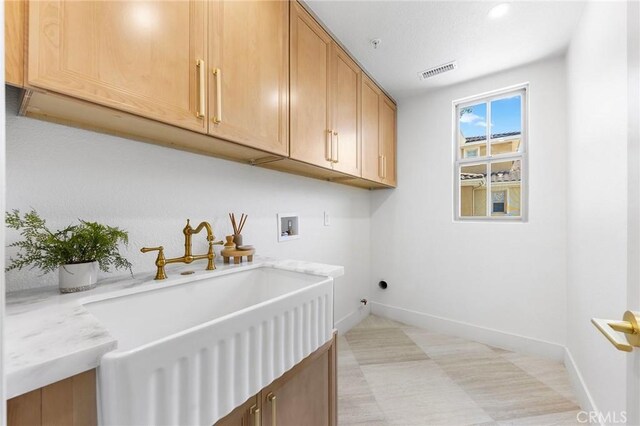 washroom featuring cabinets, washer hookup, sink, and electric dryer hookup